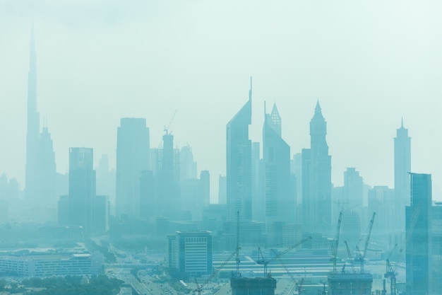 Beautiful skyline of Dubai surrounded by sand dust at day light