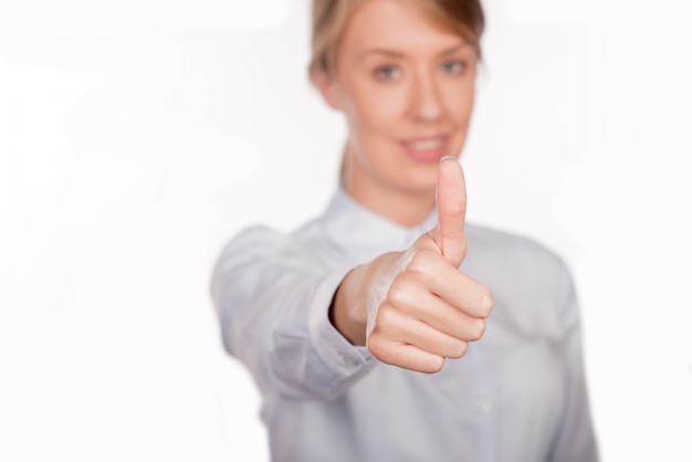 Free photo beautiful smiling business woman standing against white background. thumb up.