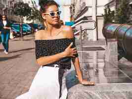 Free photo beautiful smiling model dressed in elegant summer clothes.sexy carefree girl sitting in the street.trendy modern businesswoman in sunglasses having fun