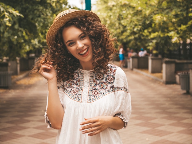 Free photo beautiful smiling model with afro curls hairstyle dressed in summer hipster white dress.