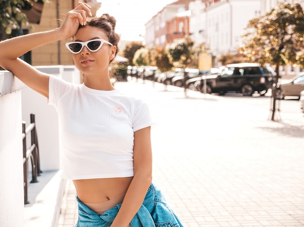 Free Photo beautiful smiling model with horns hairstyle dressed in summer hipster jacket jeans clothes.sexy carefree girl posing in the street.trendy funny and positive woman having fun in sunglasses