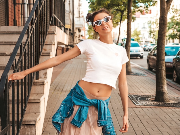 Free photo beautiful smiling model with horns hairstyle dressed in summer hipster jacket jeans clothes.sexy carefree girl posing in the street.trendy funny and positive woman having fun in sunglasses