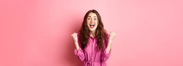 Free photo beautiful smiling woman scream with happy and excited face saying yes making fist pump winning and f