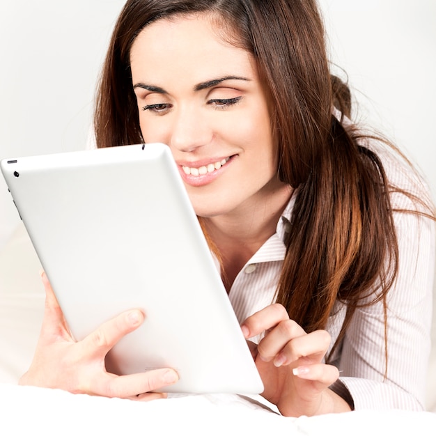 Beautiful smiling woman on sofa with tablet