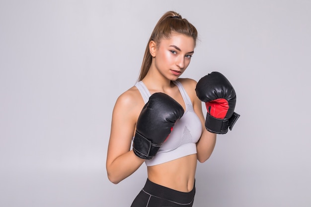 Beautiful smiling young fitness woman wears boxing gloves