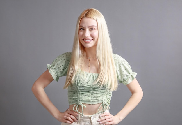 Beautiful smiling young woman with perfect skin face natural beauty concept isolated on grey studio background