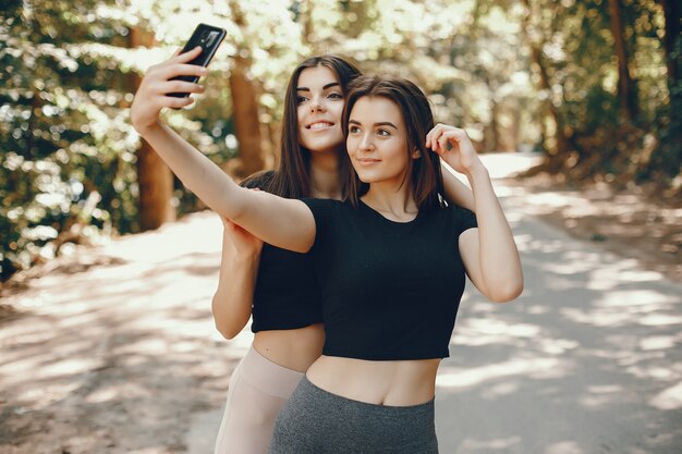 Beautiful sportsgirls in a summer sunny park