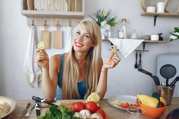 Beautiful and sporty girl in a kitchen with a vegetables