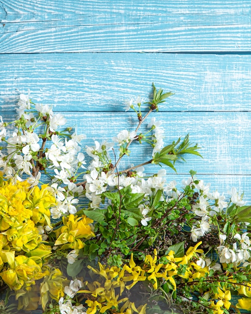 Beautiful spring flowers and blooms on a wooden background.