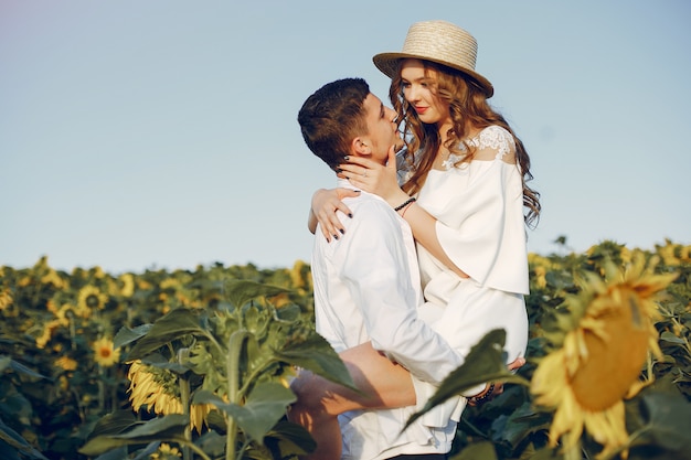 Beautiful and stylish couple in a field with sunflowers