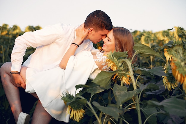 Beautiful and stylish couple in a field with sunflowers