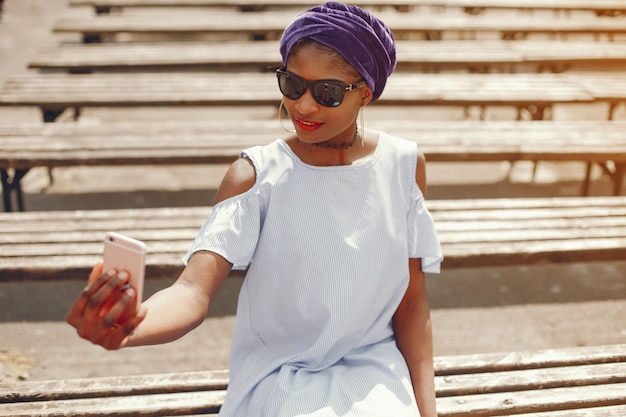 Free Photo a beautiful and stylish dark-skinned girl walks in a sunny summer city