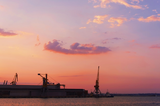 Free Photo beautiful sunset over the industrial area of a suburban city with the sun reflecting on water