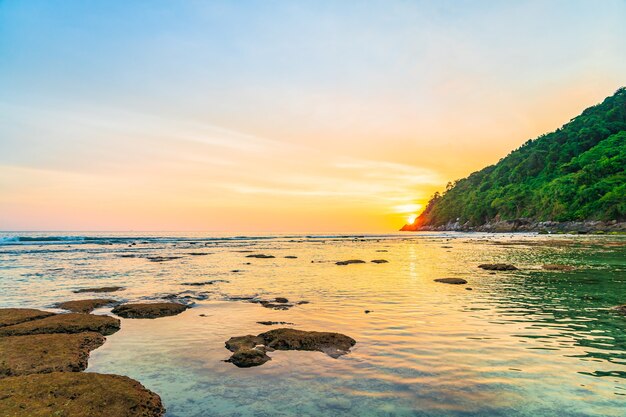 Beautiful sunset over mountain around beach sea ocean and rock