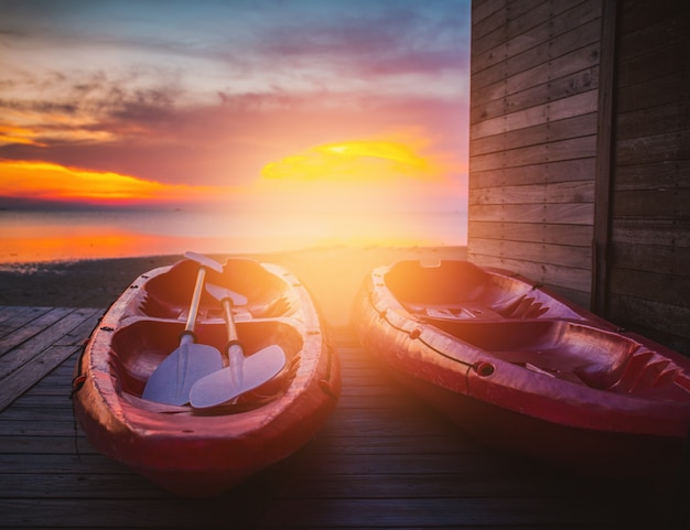 The beautiful sunset with couple red Kayak boat with sun lay.