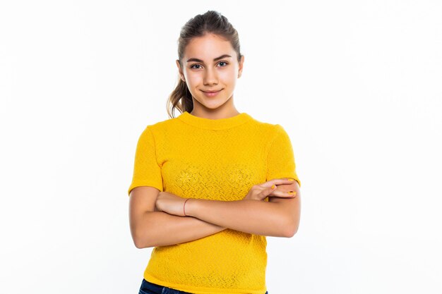 Beautiful teen girl student with confident expression, keeps arms folded. Portrait of smiling teenager isolated on white wall.