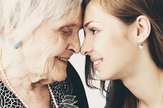 Beautiful teenager girl and her grandmother, family portrait