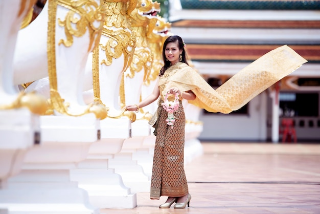 Free photo beautiful thai woman in thai traditional costume at temple