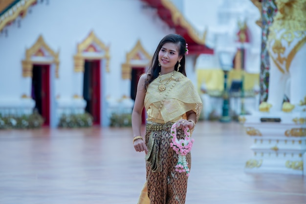 Free photo beautiful thai woman in traditional dress costume in phra that choeng chum thailand temple