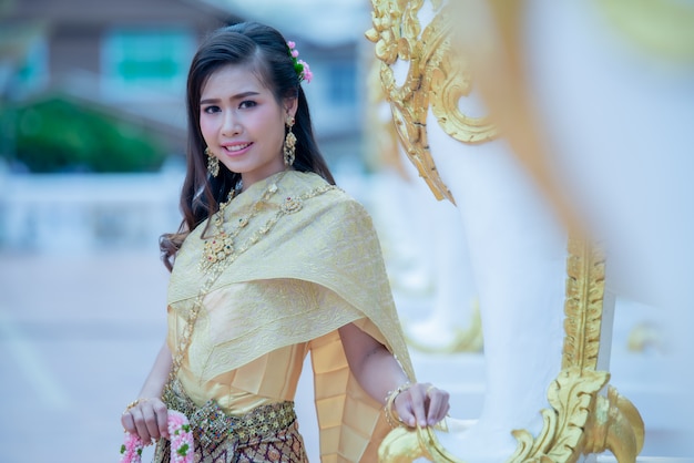 Free photo beautiful thai woman in traditional dress costume in phra that choeng chum thailand temple