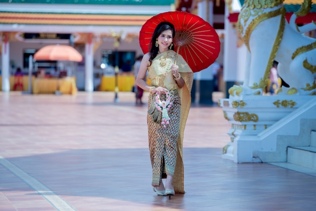 Free photo beautiful thai woman in traditional dress costume in phra that choeng chum thailand temple