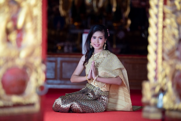 Beautiful Thai woman in traditional dress costume, temple thailand