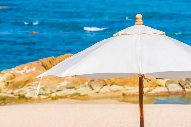 Free photo beautiful tropical beach sea with umbrella and chair around white cloud and blue sky for vacation travel