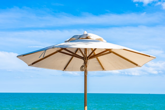 Beautiful umbrella and chair around beach sea ocean with blue sky for travel