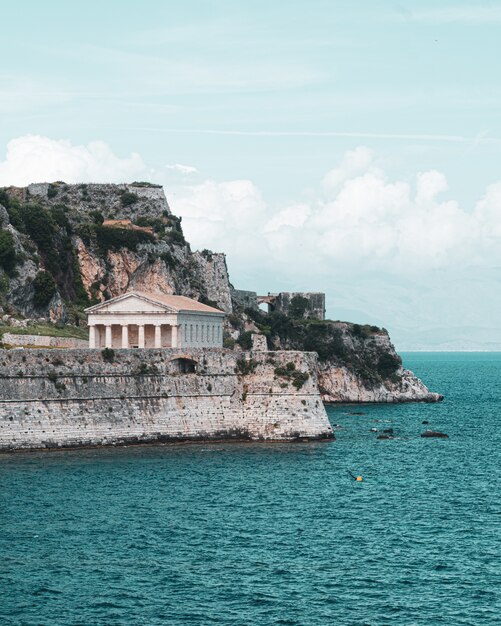 Beautiful vertical shot of an ancient temple and the sea in one of the Greek islands