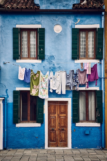 Beautiful vertical symmetric shot of a suburban blue building with clothes hanging on a rope