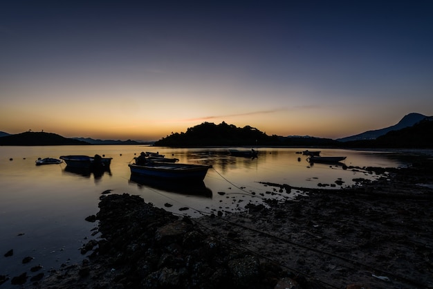 Free Photo beautiful view of the boats by the shore under the sunset in the sky