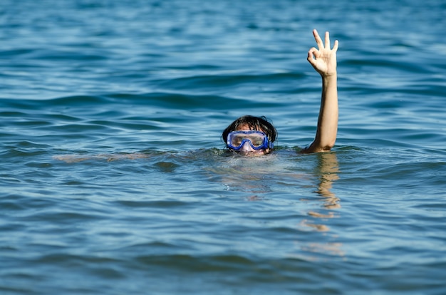 Beautiful view of a female swimming in the lake with only her head and one arm out of the water