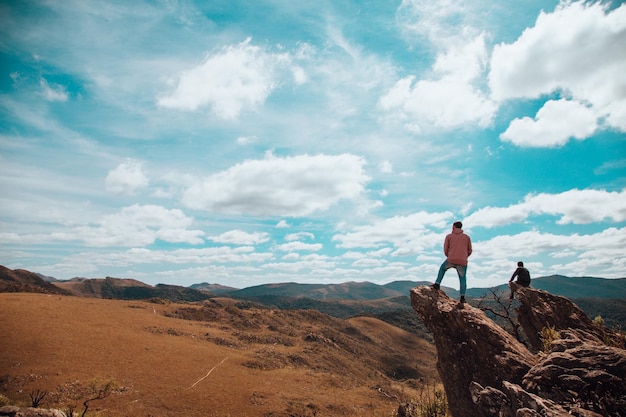 Beautiful view of humans at the edge of the cliff on a sunny day