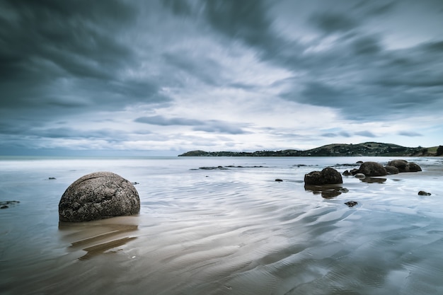 Free photo beautiful view of the sea with rocks on the shore and mountains in the distance