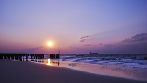 Beautiful view of the sunset with purple clouds over the beach