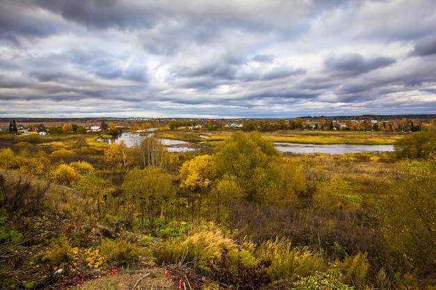 Free photo beautiful village in russia in autumn, with the the beautiful yellow trees under the cloudy sky