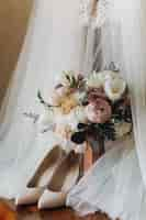 Free photo beautiful wedding shoes, dress and flower bouquet