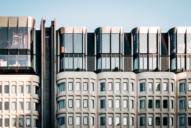 Beautiful wide shot of modern white architecture with large glass windows under a clear blue sky