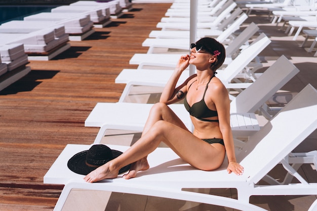 Free photo beautiful woman in bikini by the pool