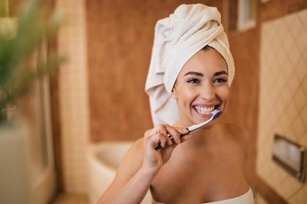 Beautiful woman brushing teeth with a toothbrush in the bathroom