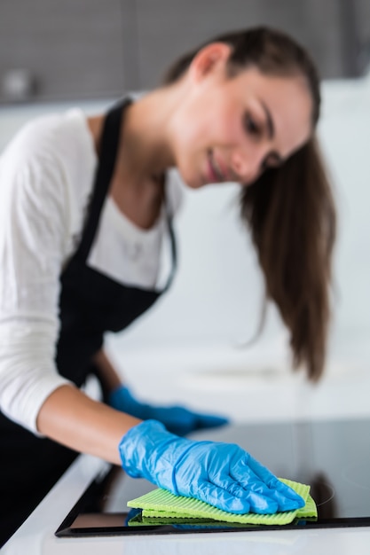 Free Photo beautiful woman doing the housework while cleaning in the kitchen