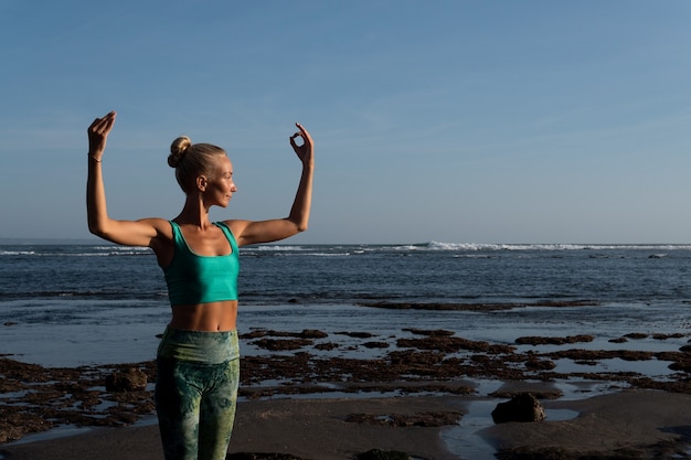 Beautiful woman doing yoga on the beach