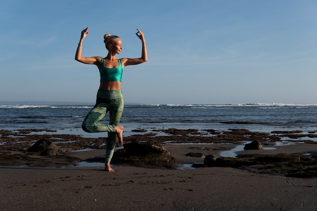 Beautiful woman doing yoga on the beach