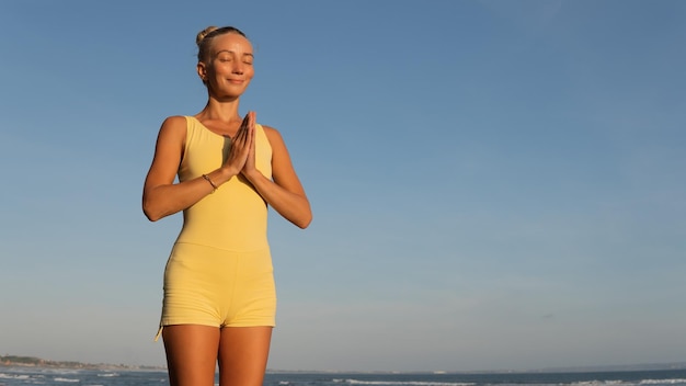 Beautiful woman doing yoga on the beach