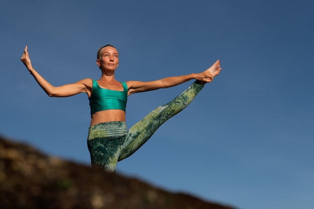 Beautiful woman doing yoga. middle plan