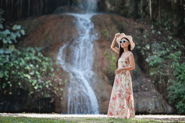 Beautiful woman in dress by the waterfall