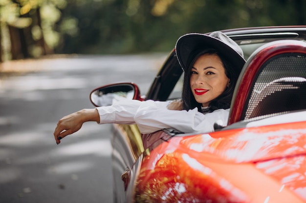 Beautiful woman driving red cabrio