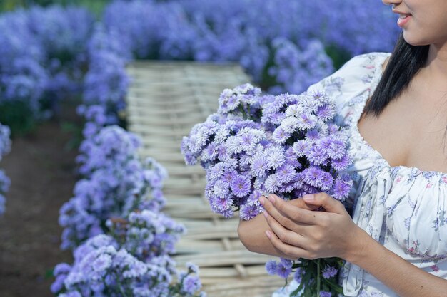 Beautiful woman enjoying flowers field