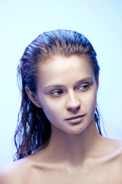 Beautiful woman face portrait close up on blue background