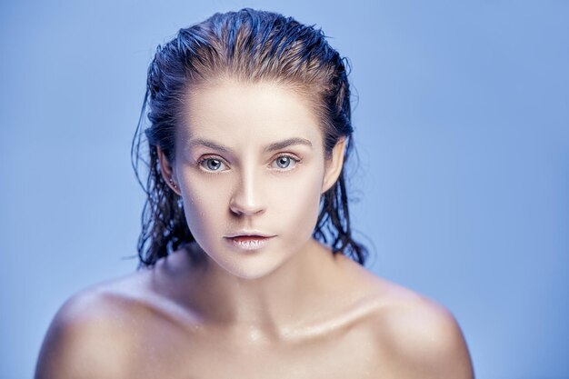 Beautiful woman face portrait close up on blue background